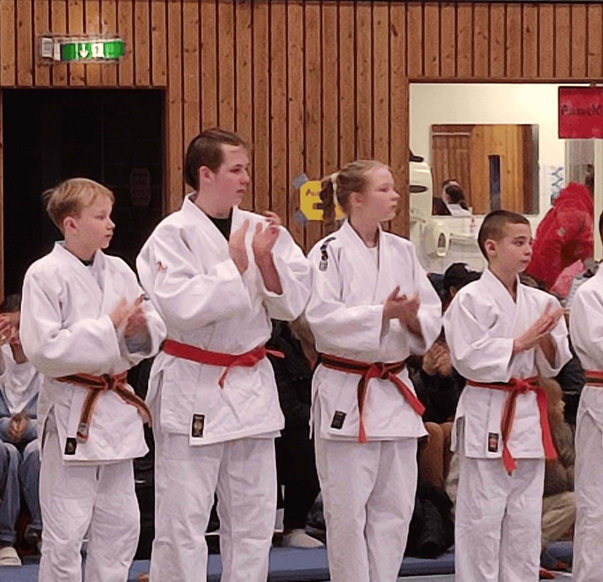 Judoka in weißen Anzügen am Mattenrand