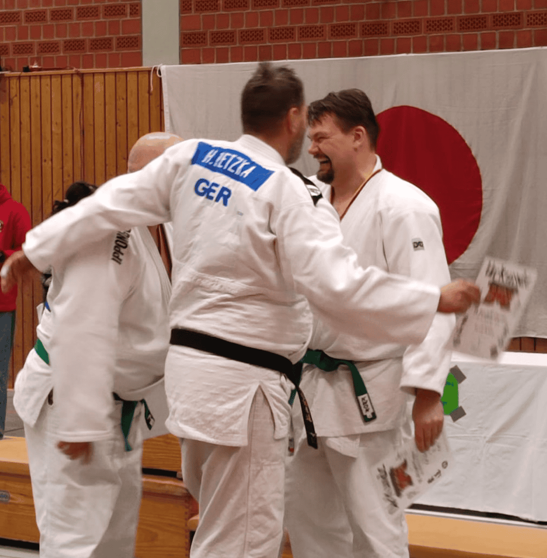 Judoka gratulieren einander am Podest